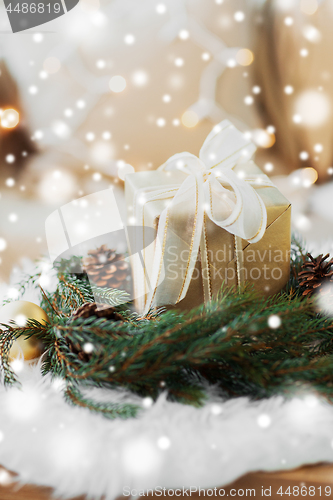 Image of christmas gift and fir wreath with cones and balls