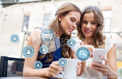 Image of women using car sharing app on smartphone at cafe