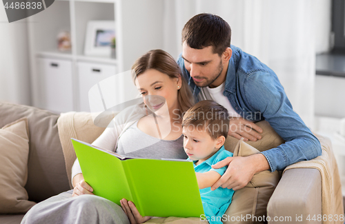 Image of happy family reading book at home