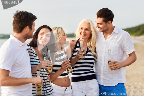 Image of happy friends drinking non alcoholic beer on beach
