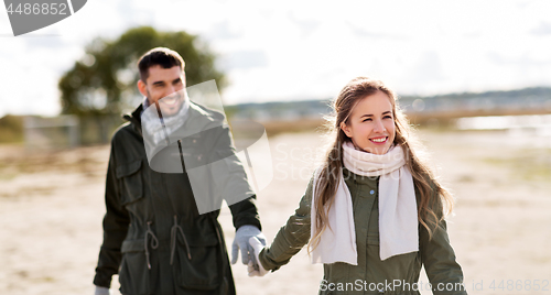 Image of couple walking along autumn beach