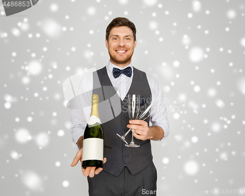 Image of man with bottle of champagne and glasses at party