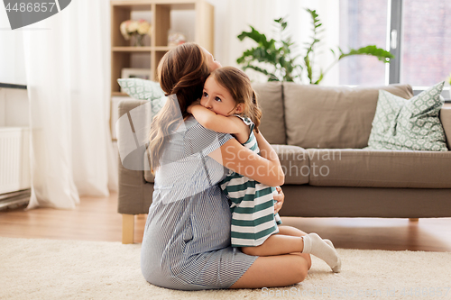 Image of pregnant mother and daughter hugging at home
