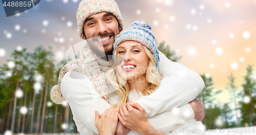 Image of couple hugging over winter forest and snow