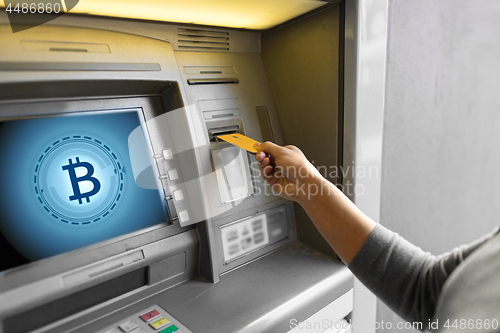 Image of close up of woman inserting card to atm machine