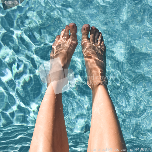 Image of Female feet in turquoise water