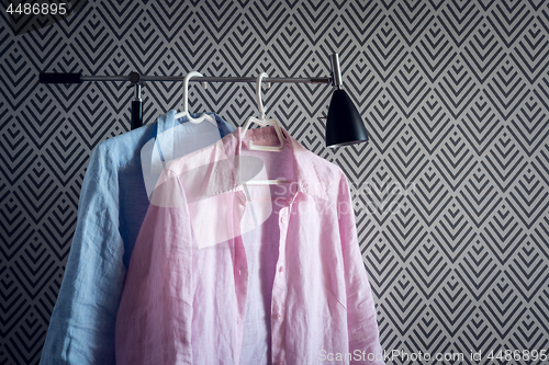 Image of Pink and blue shirts on wallpaper background