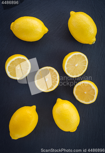 Image of Whole and cut lemons on dark background