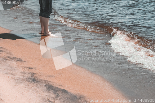 Image of Man standing in water by the seaside