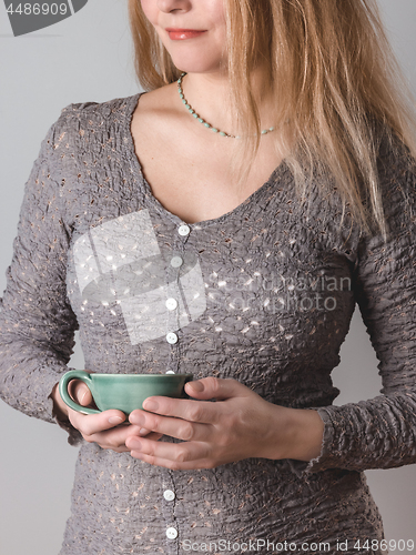 Image of Young woman with turquoise teacup