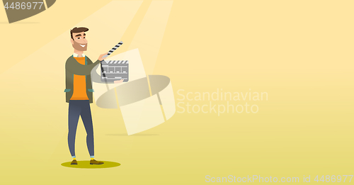 Image of Smiling man holding an open clapperboard.