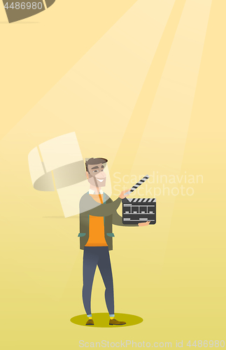 Image of Smiling man holding an open clapperboard.