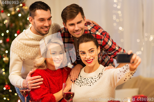 Image of friends taking selfie at christmas dinner