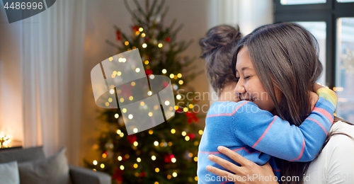 Image of happy mother hugging her daughter on christmas