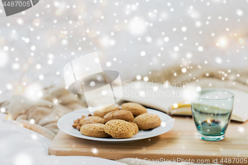 Image of oatmeal cookies and candle in holder at home