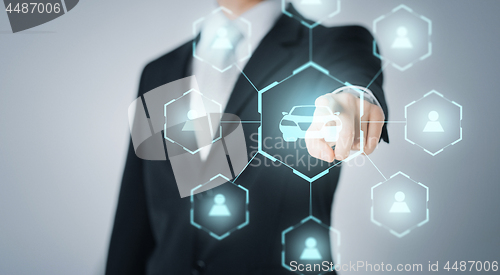 Image of businessman with virual hologram of car sharing