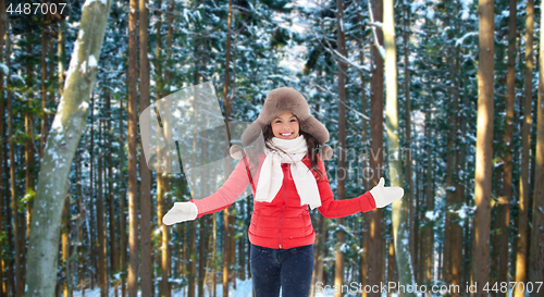 Image of happy woman in fur hat over winter forest