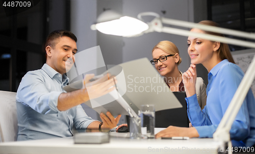 Image of business team with papers working late at office