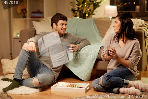 Image of happy couple drinking coffee and eating at home