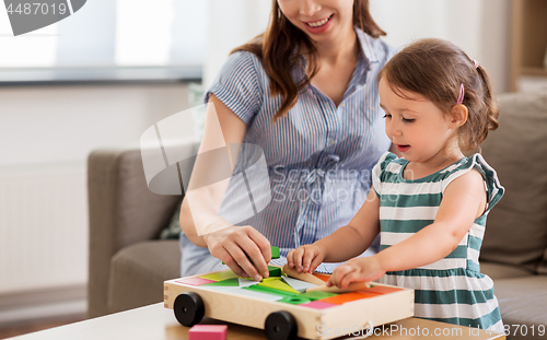 Image of pregnant mother and daughter with toy blocks