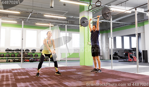 Image of man and woman with weights exercising in gym