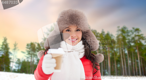 Image of woman in fur hat with coffee over winter forest