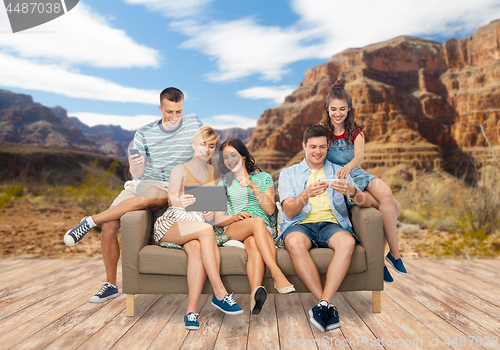 Image of friends with modern gadgets over grand canyon