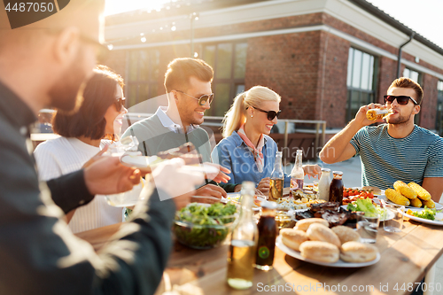 Image of friends having dinner or bbq party on rooftop