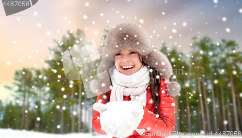 Image of woman in fur hat with snow over winter forest