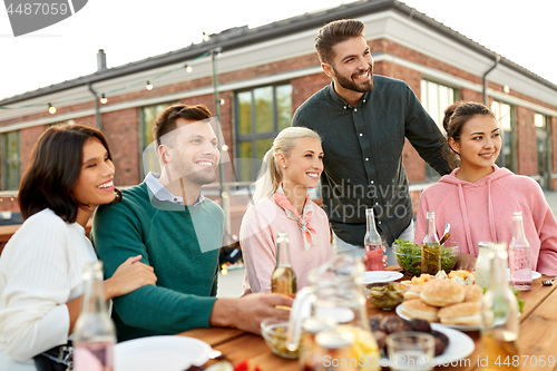 Image of happy friends with drinks or bbq party on rooftop