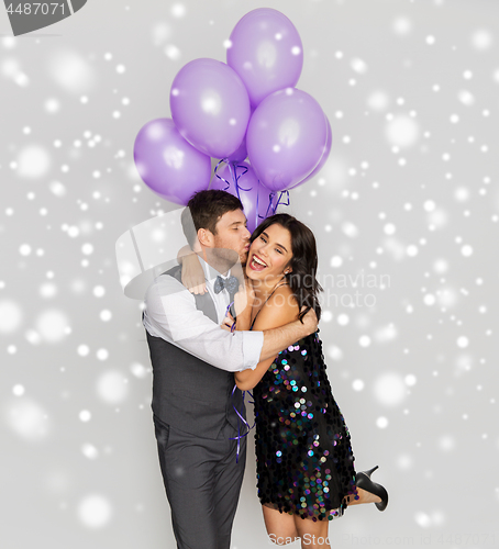 Image of happy couple with violet balloons kissing at party