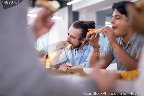 Image of multiethnic business team eating pizza