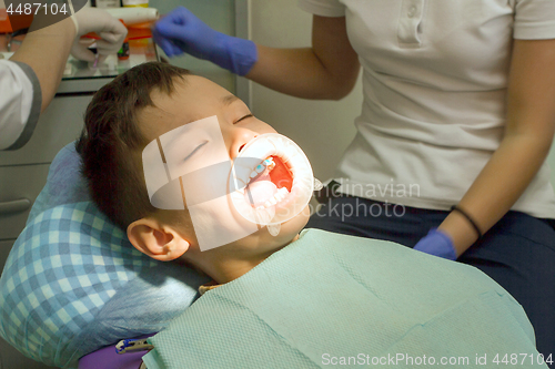 Image of Orthodontist examining boy mouth