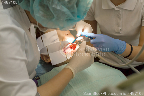 Image of Orthodontist examining boy mouth