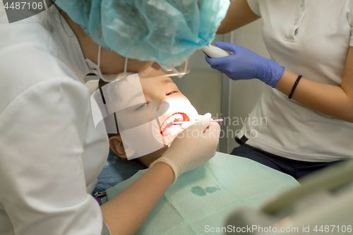 Image of Orthodontist examining boy mouth