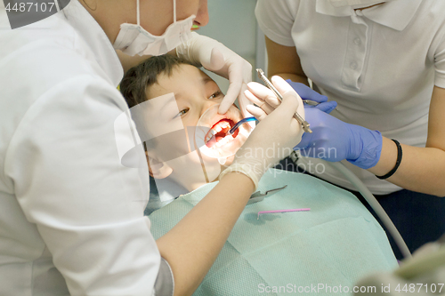 Image of Orthodontist examining boy mouth