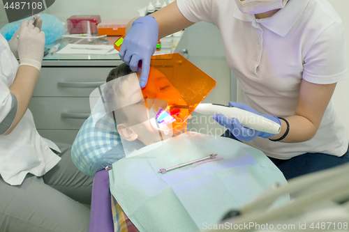 Image of Orthodontist examining boy mouth