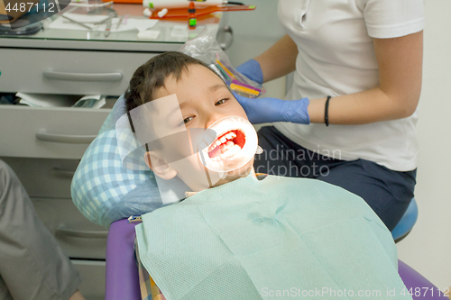 Image of Orthodontist examining boy mouth