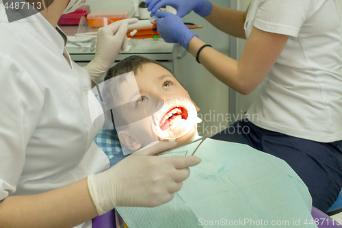 Image of Orthodontist examining boy mouth