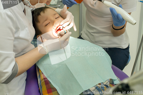 Image of Orthodontist examining boy mouth