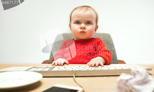 Image of Happy child baby girl toddler sitting with keyboard of computer isolated on a white background
