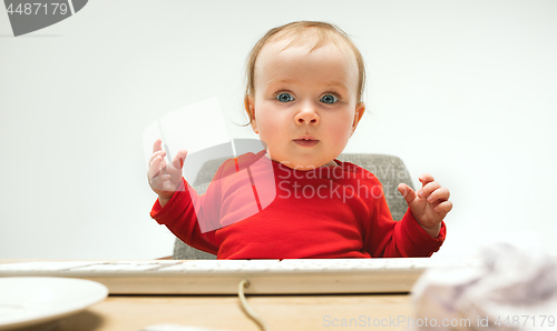 Image of Happy child baby girl toddler sitting with keyboard of computer isolated on a white background