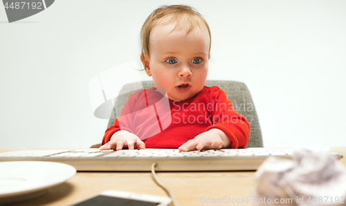 Image of Happy child baby girl toddler sitting with keyboard of computer isolated on a white background