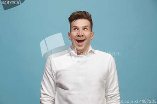 Image of The happy business man standing and smiling against studio background.