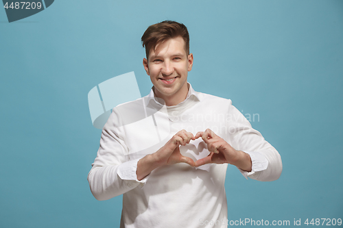 Image of The happy business man standing and smiling against studio background.