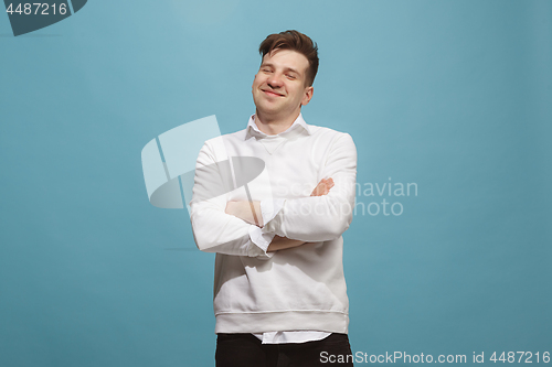 Image of The happy business man standing and smiling against studio background.