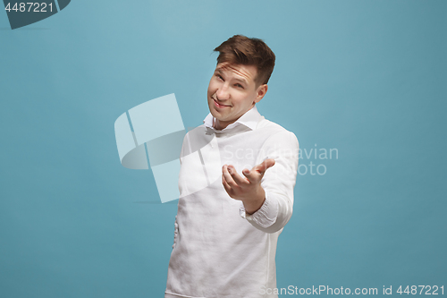 Image of The happy business man standing and smiling against studio background.