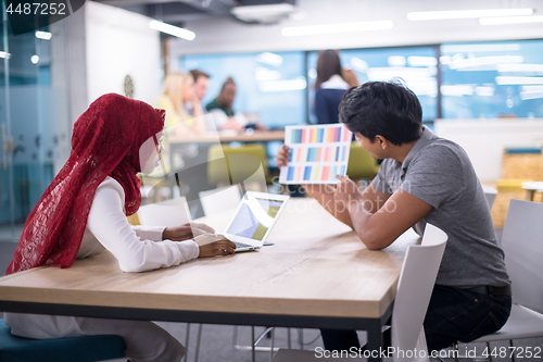 Image of black muslim business woman having a meeting with her indian mal