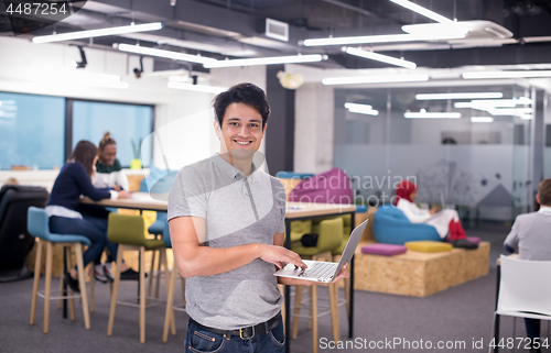 Image of portrait of young indian businessman using laptop computer