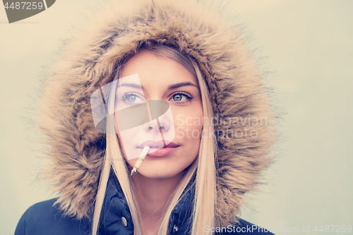 Image of portrait of young blonde girl with cigarette in the mouth